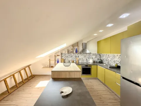 Modern kitchen with yellow cabinets and a sloped ceiling. - image 5