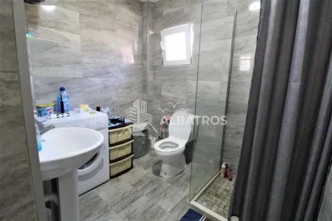 Bathroom with a shower cabin, washbasin, toilet, and washing machine. - image 6