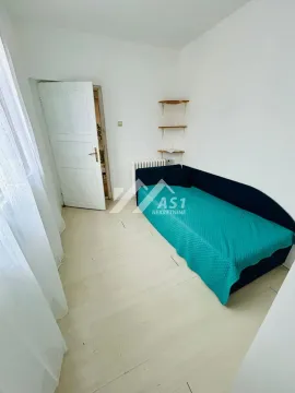 Manja spavaća soba sa krevetom i belim zidovima. - image 10