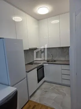Small modern kitchen with white cabinetry and built-in appliances. - image 4