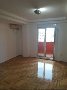 Prazna soba sa parketom i izlazom na balkon. - image 2