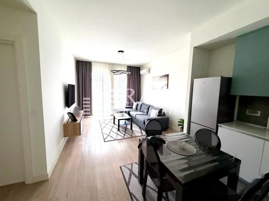 Living room with dining area and kitchen in a bright interior.