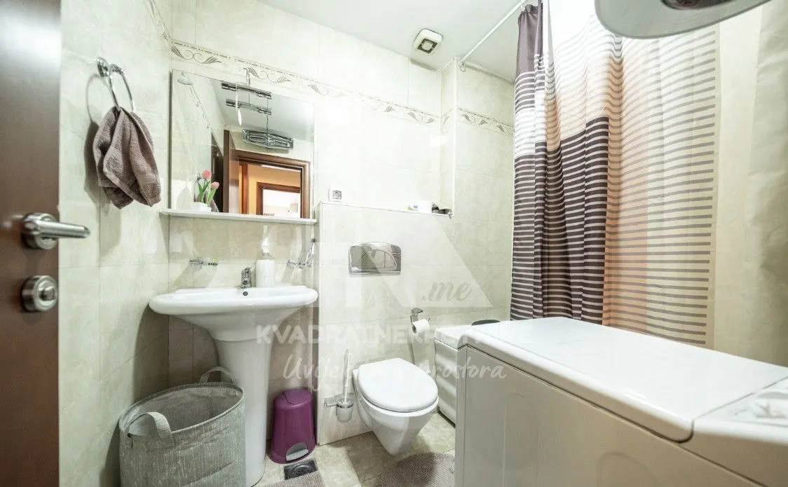 Compact bathroom with a sink, toilet, and washing machine.
