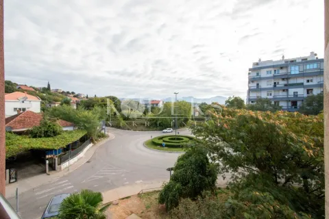 Pogled sa prozora na okolne zgrade, kružni tok i zelenilo. - image 12