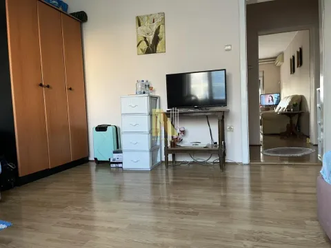 Spavaća soba sa velikim drvenim ormarom, TV-om i pogledom na prolaz prema drugoj prostoriji. - image 7