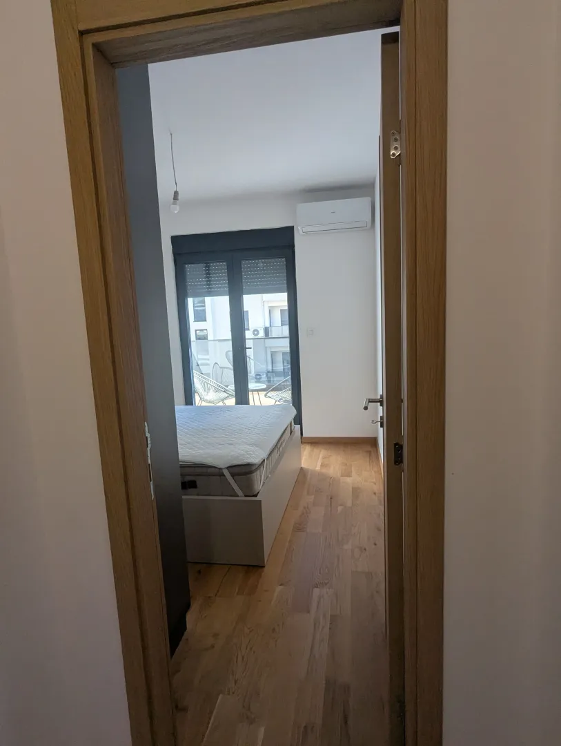 View through the doorway into a furnished bedroom with access to the terrace.