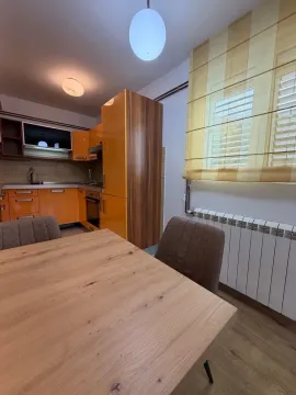 Kitchen with orange cabinets and a dining table. - image 3