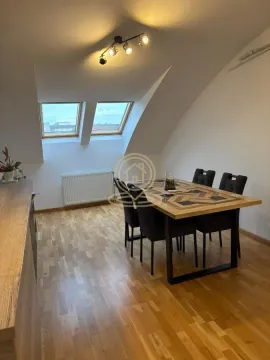 Trpezarija sa drvenim stolom i crnim stolicama u potkrovlju. - image 4