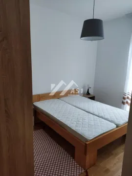 Spavaća soba sa bračnim krevetom i drvenim podom. - image 7