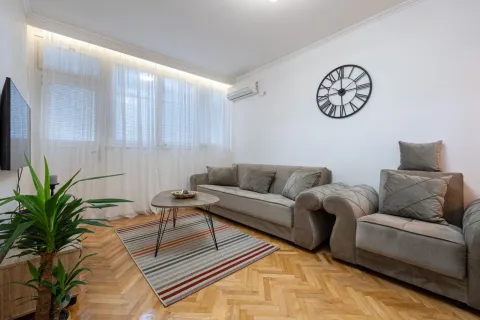 Living room with a sofa, coffee table and a large window. - image 3