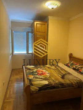 Furnished bedroom with a wooden bed and wardrobe. - image 3