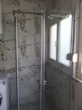 Moderna tuš kabina sa staklenim paravanom u mermernom kupatilu. - image 7