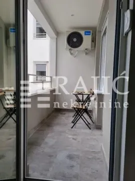 Small enclosed balcony with a table and chairs. - image 11