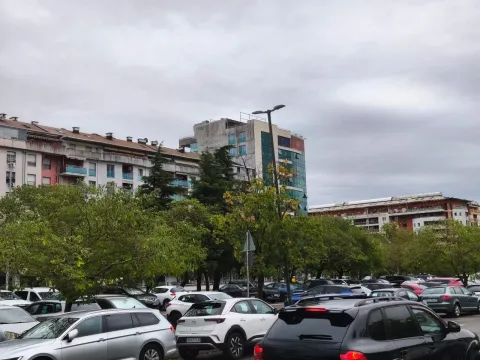 View of a city parking lot and surrounding residential buildings. - image 4
