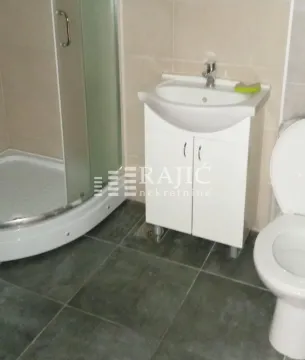 Smaller bathroom with a shower cabin, washbasin, and toilet. - image 5