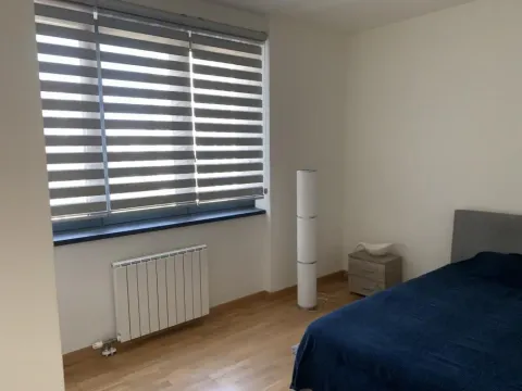 Bedroom with a bed, window with blinds, and parquet flooring. - image 6