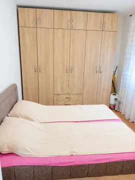Spavaća soba sa bračnim krevetom i velikim drvenim ormarom. - image 5