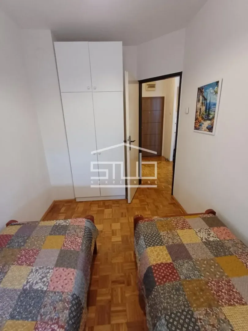 Bedroom with two single beds and a built-in wardrobe.
