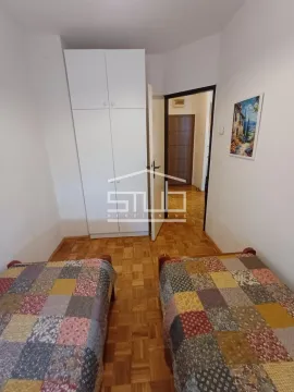 Bedroom with two single beds and a built-in wardrobe. - image 4