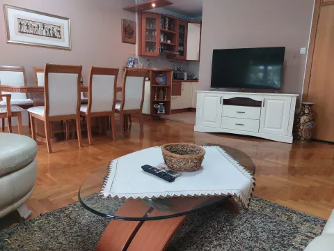 A bright living room with a dining table, coffee table, and TV. - image 3