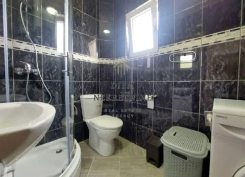 Kupatilo sa tuš kabinom, WC šoljom, umivaonikom i pločicama tamne boje. - image 8
