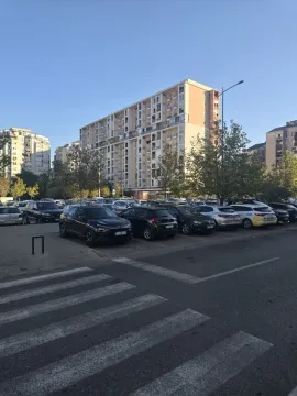 View of the apartment building and the parking lot in front of the entrance. - image 17