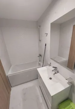 Modern bathroom with a bathtub, washbasin, and mirror. - image 10