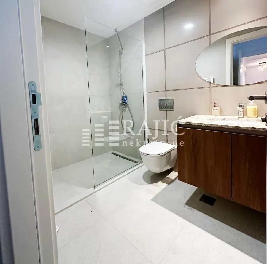 Modernly equipped bathroom with a walk-in shower and vanity.