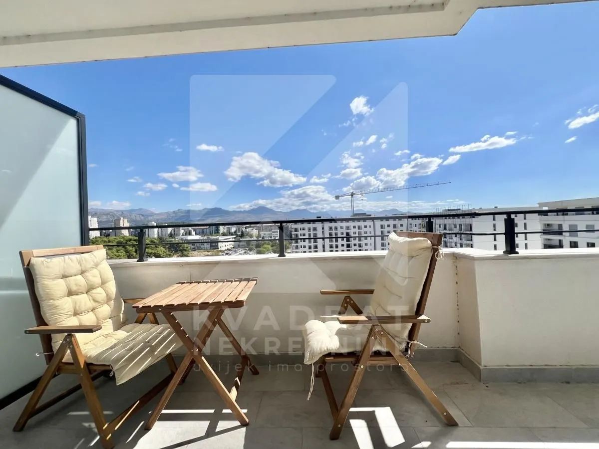 Spacious balcony with outdoor seating and a city view.