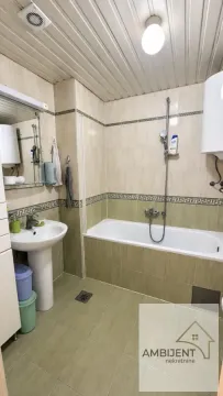 Kupatilo sa kadom, umivaonikom i pločicama u bež i zelenim tonovima. - image 8