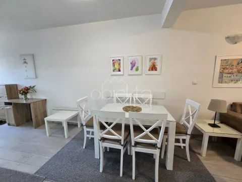 Dining area with a white table and chairs as part of the living room. - image 4