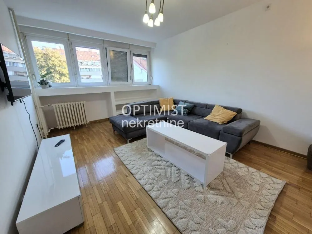 Living room with a sofa and parquet flooring.