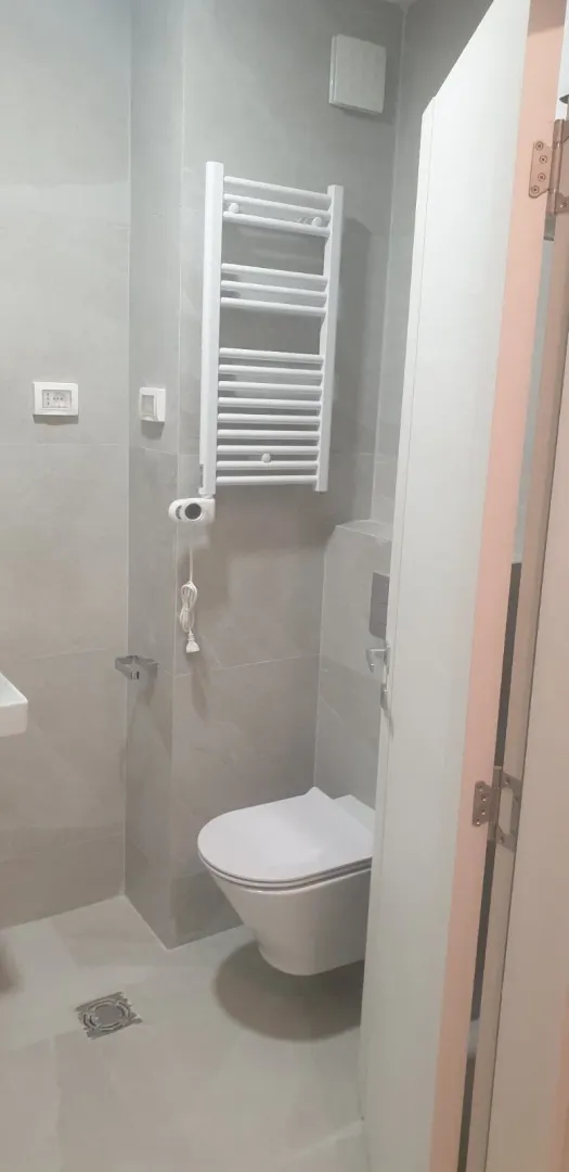 Bright bathroom with a wall-hung toilet and a towel radiator.