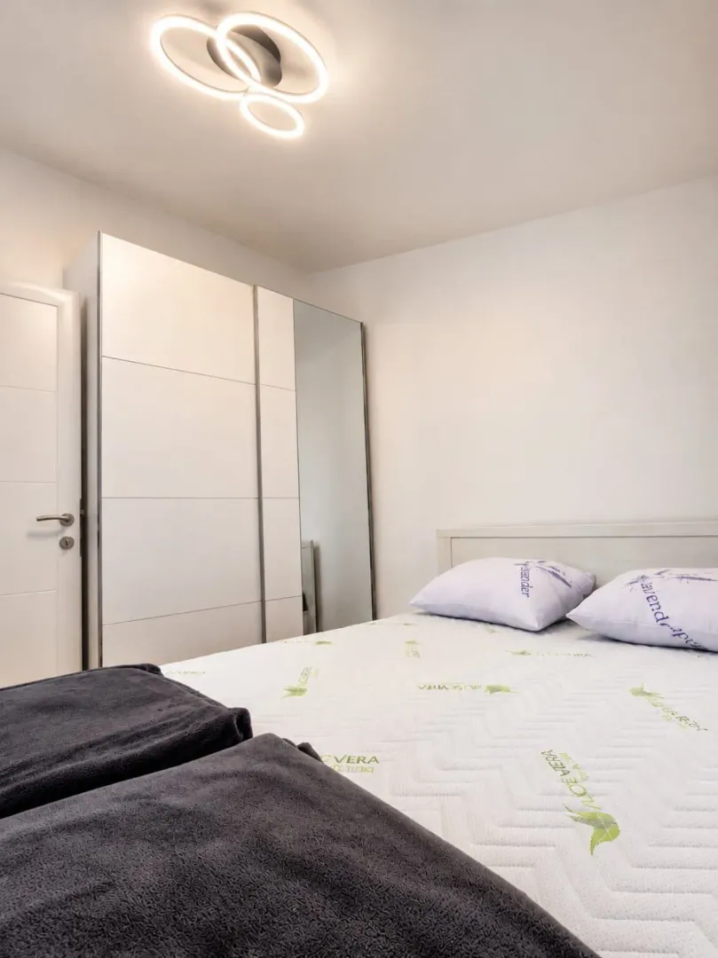 Bright and tidy bedroom with a double bed and wardrobe.