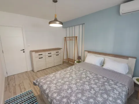 Furnished bedroom with a double bed, chest of drawers, and air conditioning. - image 6