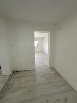 Prazna prostorija sa laminatnim podom i prolazom u drugu sobu. - image 7