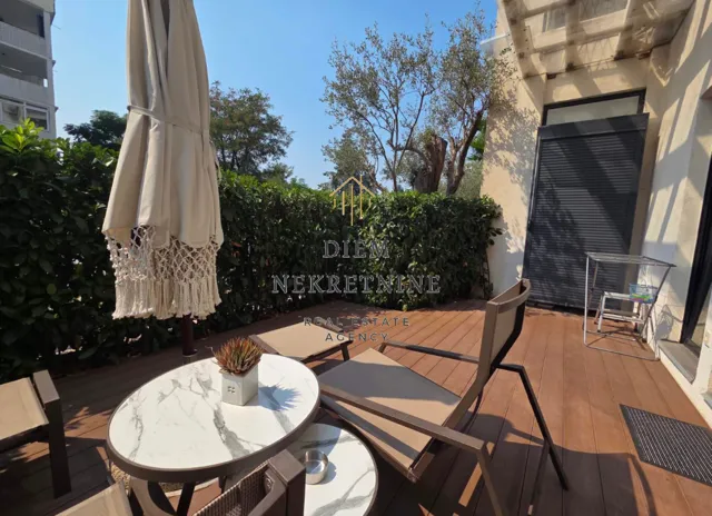 Furnished terrace with seating set and umbrella.