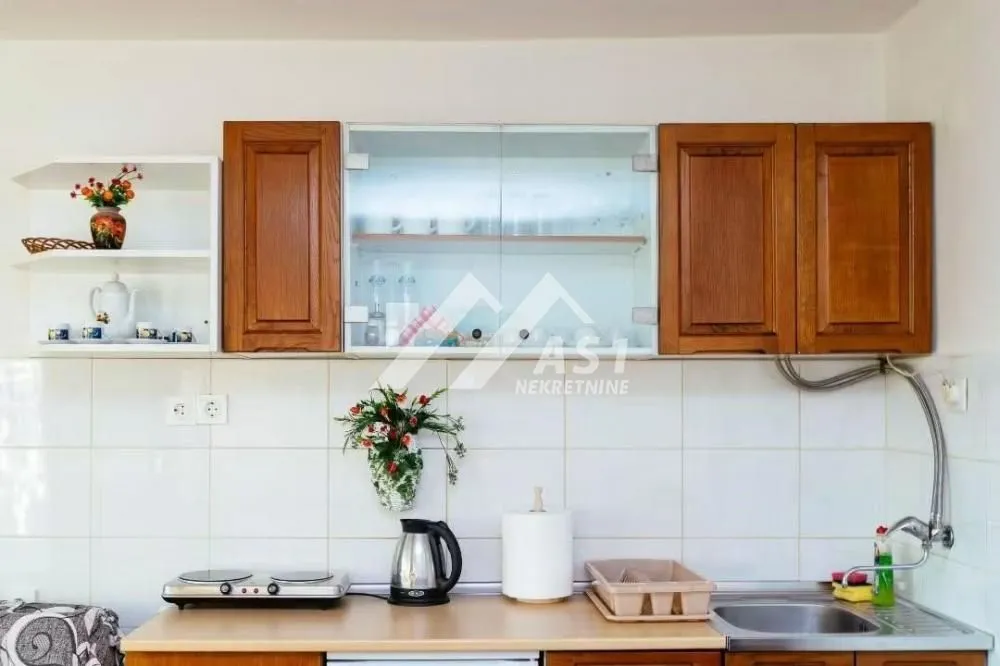 View of the kitchen cabinets and countertop with a sink.