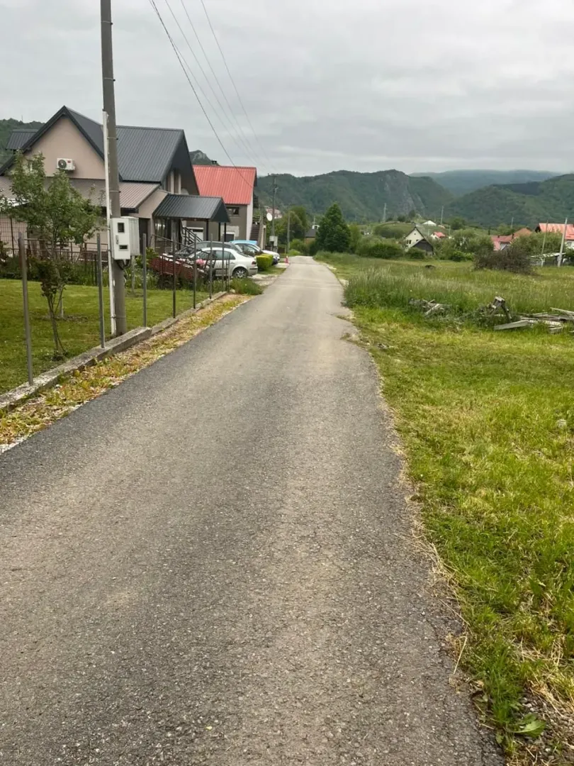 Asfaltni put koji vodi pored kuća u prigradskom naselju.