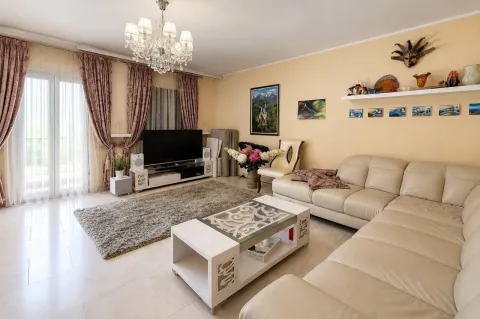Spacious living room with a sofa set, TV, and dining area. - image 3