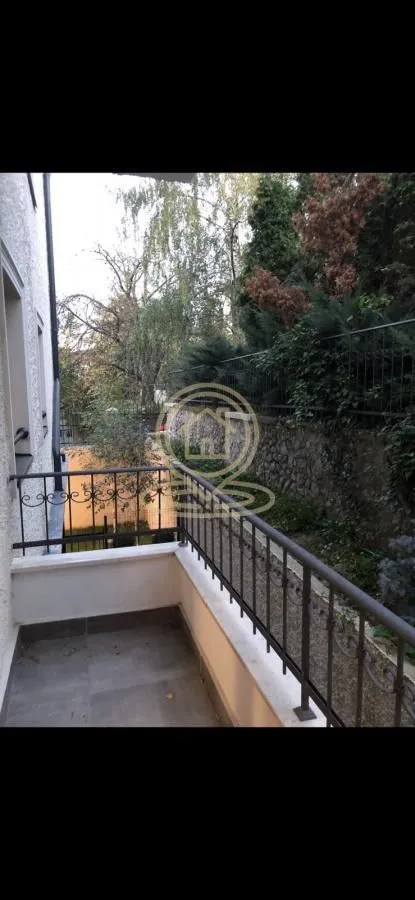 Balcony with a metal railing and a view of the courtyard and greenery.