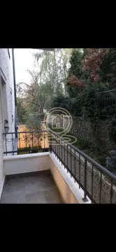 Balcony with a metal railing and a view of the courtyard and greenery. - image 4