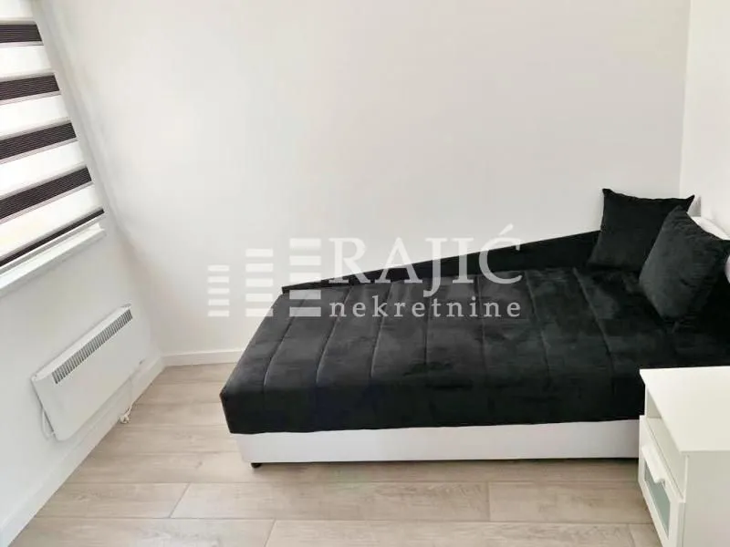Small bedroom with a bed and a window.