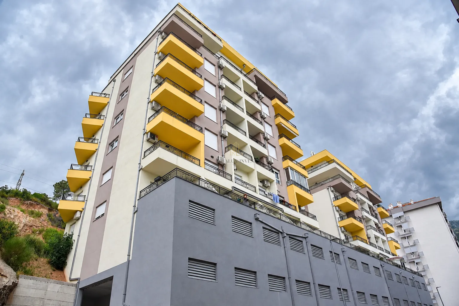 View of a multi-story residential building with balconies and a modern facade.