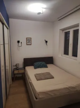 Small bedroom with a double bed, wardrobe, and a window. - image 5