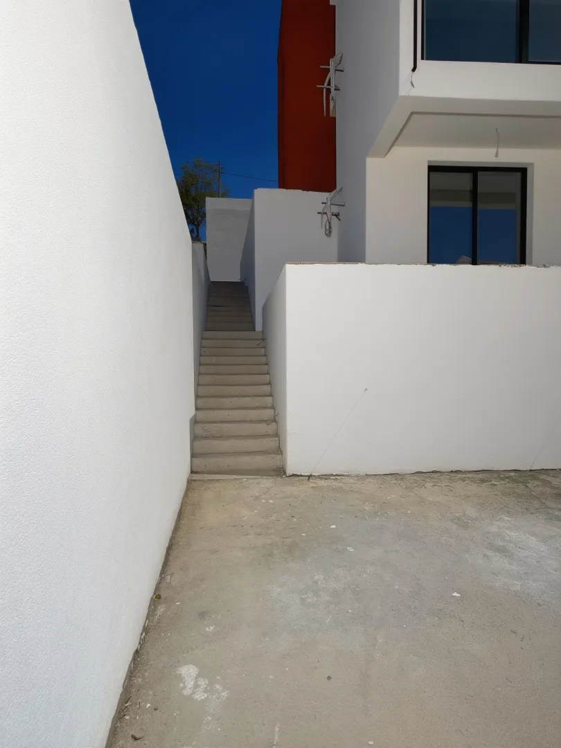 Exterior of the house with external stairs and yard.