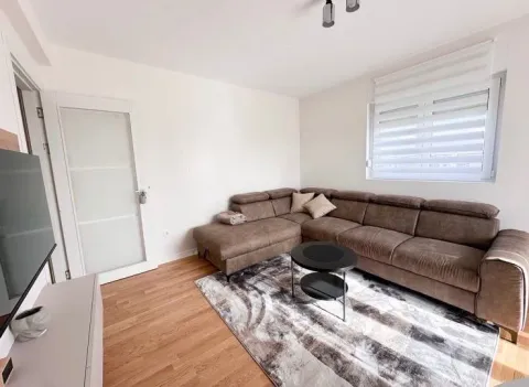 Living room with a corner sofa, a coffee table, and a TV. - image 4