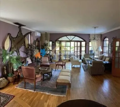Spacious living room with seating furniture, wooden flooring, and large glass doors. - image 6