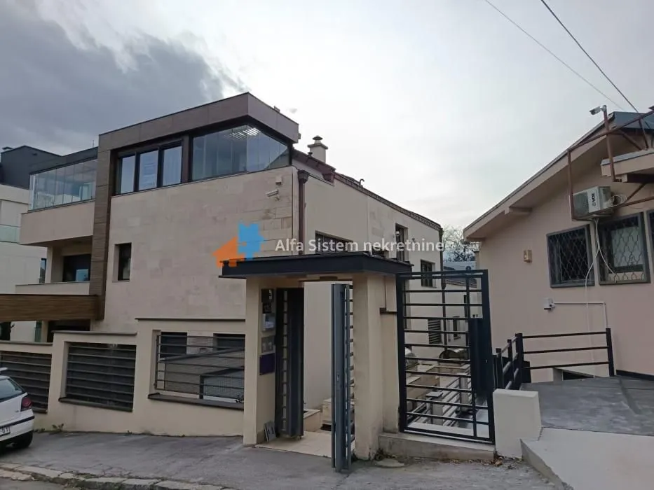 View of the building exterior with entrance gate and fence.
