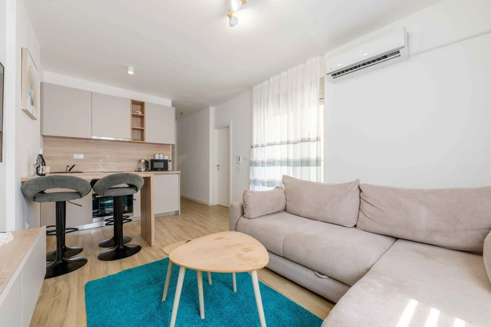 Living room with sofa and kitchen in an open space.